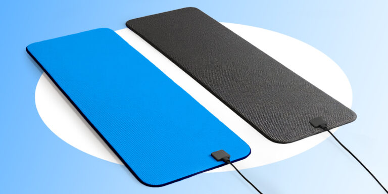 A blue pemf therapy mat and a black grounding mat lying next to each other